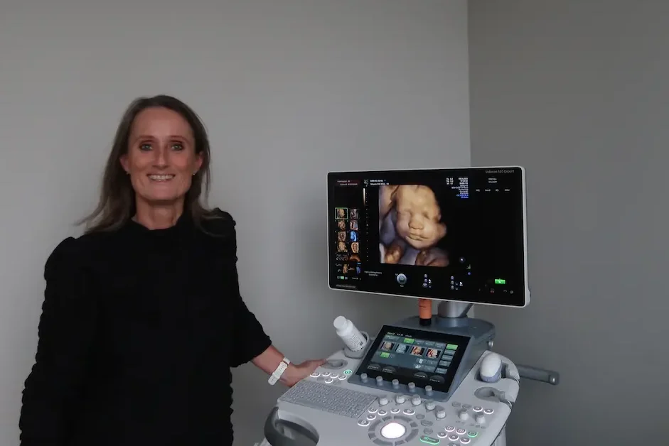 Professionel sonograf ved avanceret ultralydsscanner med 3D-billede af foster i klinik